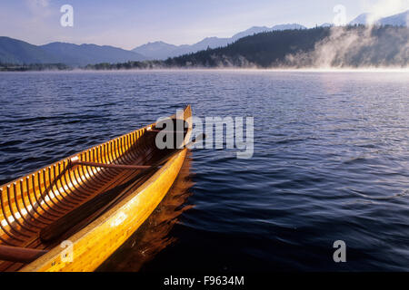 Zeder Kanu wartet Paddler, wie der Nebel auf Alta Lake im Herbst, Whistler, BC Kanada steigt Stockfoto