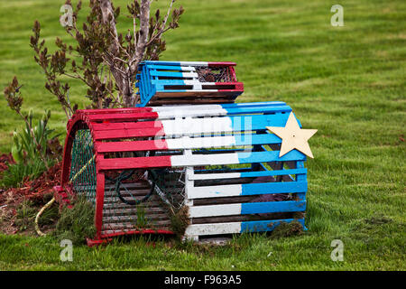 Klein und Regularsize Hummerfallen lackiert in den Farben der Acadian Flagge, auf dem Rasen eines privaten Wohnhauses in Stockfoto