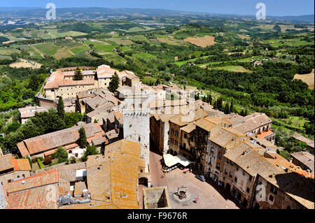 Blick von oben auf San Gimignano mit dem Brunnen der Piazza della Cisterna und die umliegenden Hügel, Toskana, Italien Stockfoto