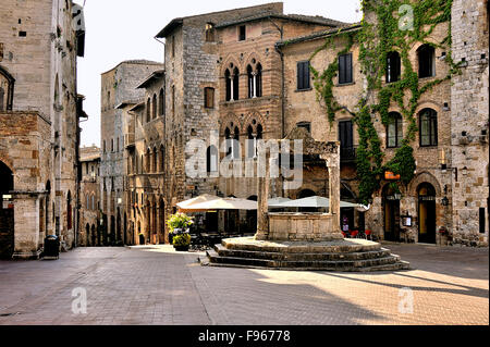 Kulisse der Piazza della Cisterna in San Gimignano, beleuchtet durch die Morgensonne, Toskana, Italien Stockfoto