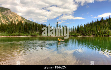 Mann, Paddeln in einem Schlauchboot auf Bertha See in Waterton Lakes Nationalpark, Alberta, Kanada Stockfoto