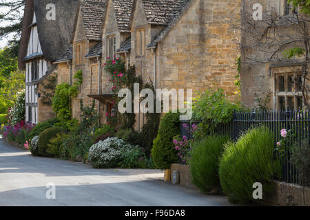 Bunte Sommerblumen und feinen Stein beherbergt Linie einer ruhigen Straße in den Cotswolds Dorf Stanton, Gloucestershire, England Stockfoto