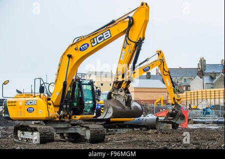 Gelbe JCB JS220 JS130 Raupe verfolgen und Bagger Baggern von TTS Anlage betrieben arbeiten an den Grundstein für die Tesco/Marks und Spencer Sanierung Standort in Mill Street / Park Avenue Aberystwyth 6. Oktober 2015 Stockfoto