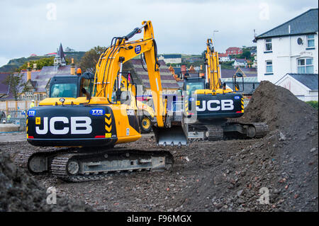 Gelbe JCB JS220 JS130 Raupe verfolgen und Bagger Baggern von TTS Anlage betrieben arbeiten an den Grundstein für die Tesco/Marks und Spencer Sanierung Standort in Mill Street / Park Avenue Aberystwyth 6. Oktober 2015 Stockfoto