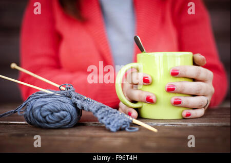 Porträt von Winter Mädchen stricken und heißes Getränk trinken hautnah Stockfoto