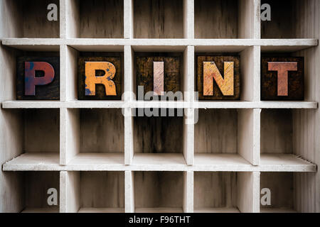 Das Wort "PRINT" Vintage Tinte geschrieben gebeizt Holz Buchdruck-Typ in einen partitionierten Drucker Schublade. Stockfoto