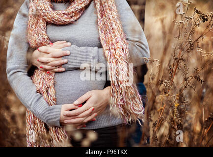 Nahaufnahme von schwangeren paar gestrickte Kleidung im Herbst Feld Stockfoto