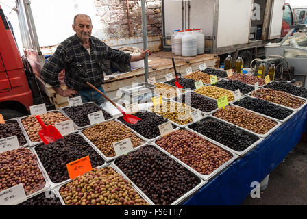 Ein Mann verkauft Oliven auf dem offenen Markt der Stadt am 24. April 2014 in Ayvalik, Türkei. Stockfoto