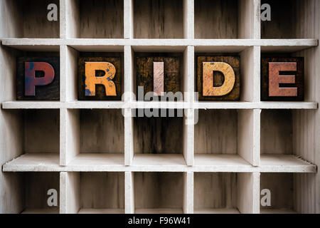 Das Wort "PRIDE" Vintage Tinte geschrieben gebeizt Holz Buchdruck-Typ in einen partitionierten Drucker Schublade. Stockfoto
