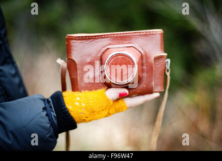 Nahaufnahme von Frau Hand mit Retro-Kamera in braune Ledertasche Stockfoto