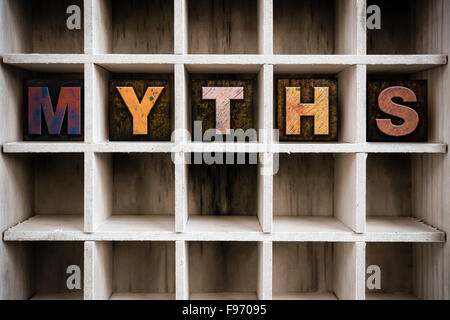Das Wort "Mythen" Vintage Tinte geschrieben befleckte hölzerne Buchdruck-Typ in einen partitionierten Drucker Schublade. Stockfoto