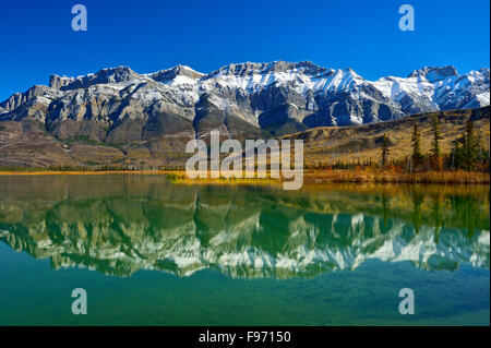 Einem schönen Landschaftsbild des schneebedeckten Miette Gebirges im Jasper National Park reflektiert in dem ruhigen Wasser der Stockfoto