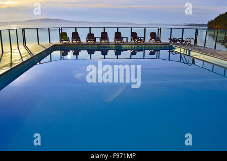 Ein horizontales Bild einen Außenpool mit einer Reihe von Stühlen in einem Ferien-Resort auf Vancouver Island b.c., Kanada. Stockfoto