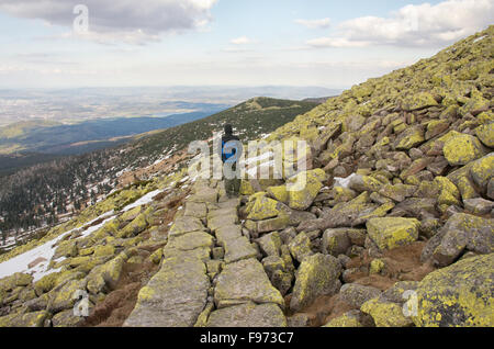 Ein einsamer Wanderer steigt von der Spitze des Sniezne Kotly in das Riesengebirge. Stockfoto