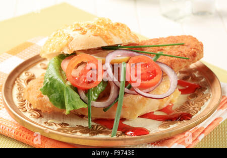 Gebratener Fisch-Sandwich garniert mit Gemüse und Himbeer Balsamico Reduktion Stockfoto