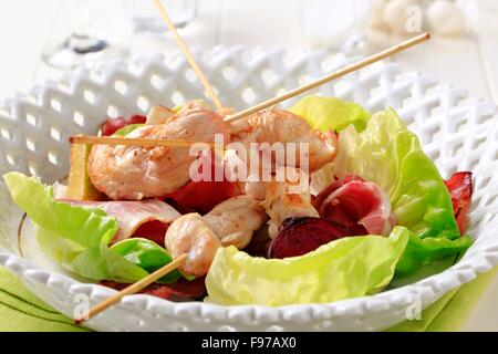 Chicken Satay mit Schinken und Salat Stockfoto