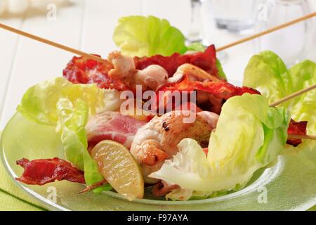 Chicken Satay mit Speckstreifen und Salat Stockfoto