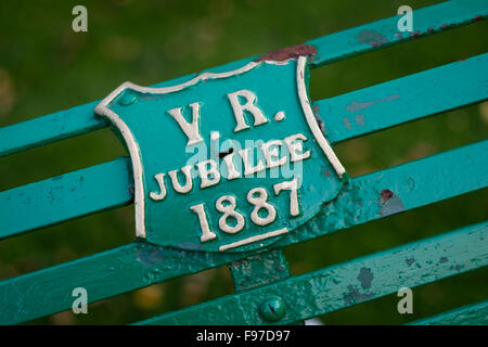 VR (Victoria Regina - Königin Victoria) 1887 Jubiläum Gedenktafel auf einer Parkbank in Cirencester, Gloucestershire, England, UK Stockfoto