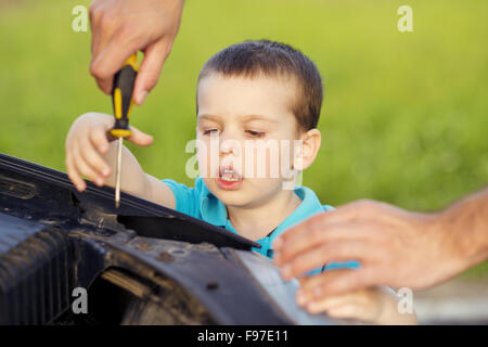 Junger Vater mit seinem kleinen Sohn Reparatur Auto Stockfoto