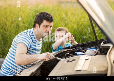 Junger Vater mit seinem kleinen Sohn Reparatur Auto Stockfoto