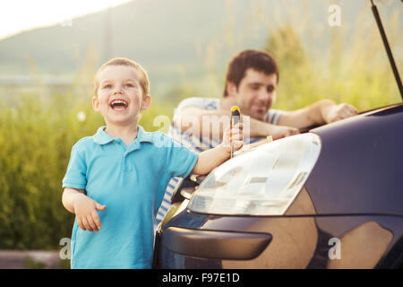 Junger Vater mit seinem kleinen Sohn Reparatur Auto Stockfoto