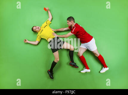 Schiedsrichter die rote Karte, ein Football-Spieler. Studio auf einem grünen Hintergrund gedreht. Stockfoto