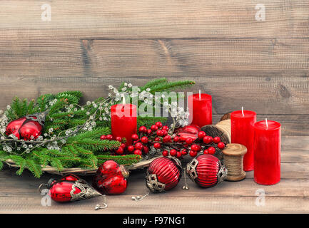 Christbaumschmuck, Spielzeug und Schmuck. Roten Kugeln und Kerzen. Ferien-Hintergrund mit grünen Zweigen Stockfoto