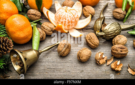 Mandarine Obst, Walnüsse und Weihnachtsbaum Äste auf hölzernen Hintergrund. Vntage Stil getönten Bild Stockfoto