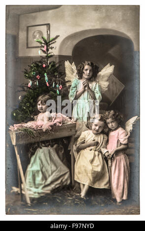 Schöne Kinder mit weißen Engel Flügel und Weihnachtsbaum. Vintage Bild mit originalen Filmkorn und Unschärfe Stockfoto