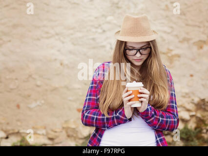 Teenager Hipster Mädchen genießen ihr wegnehmen Kaffee in Stadt Straße Stockfoto