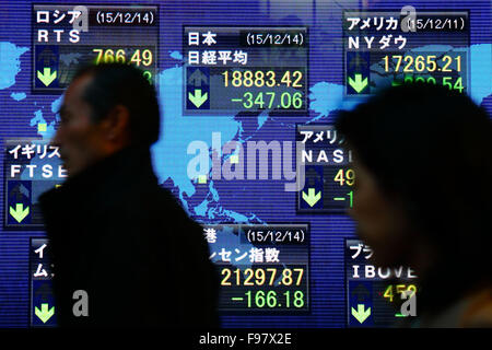 Montag. 14. Dezember 2015. Ein Fußgänger geht eine elektronische Schild mit dem Schlusskurs des Nikkei stock Durchschnitt außerhalb einer Partnerbörse in Tokio am Montag, 14. Dezember 2015. Der Nikkei-Index für 225-Ausgabe beendet 347,06 Punkte oder 1,80 Prozent auf 18,883.42, eine sechswöchigen Schließung gering. © Shingo Ito/AFLO/Alamy Live-Nachrichten Stockfoto