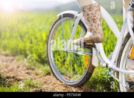 Detail der jungen Frau die Füße in Stiefeln Reiten auf Fahrrad im grünen Bereich Stockfoto