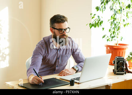 Junge Künstler Zeichnung etwas auf Grafiktablett im home-office Stockfoto