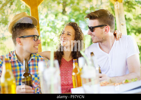 Gruppe der happy Friends trinken und Spaß haben im Gastgarten Stockfoto