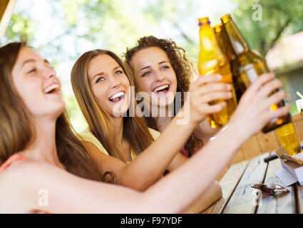 Drei glückliche Freunde Bier trinken, plaudern und Spaß im Gastgarten Stockfoto