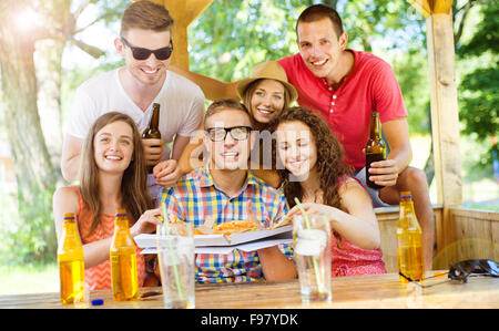 Gruppe der happy Friends Pizza im Biergarten Essen und trinken Stockfoto