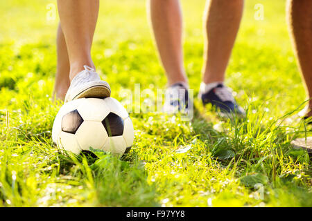 Nahaufnahme der Füße und Fußball Ball auf grünem Rasen Stockfoto
