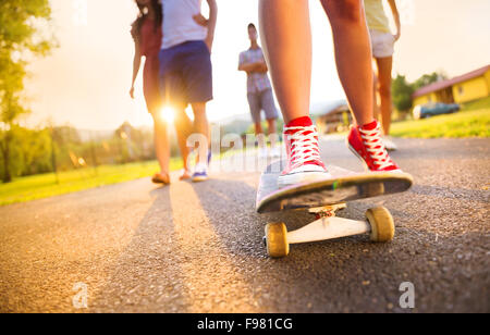 Nahaufnahme der Beine und Turnschuhe von Jugendlichen auf skateboard Stockfoto