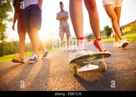 Nahaufnahme der Beine und Turnschuhe von Jugendlichen auf skateboard Stockfoto