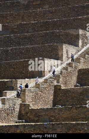 Menschen steigen die landwirtschaftlichen Terrassen auf den Inka-Ruinen von Ollantaytambo im Heiligen Tal von Peru. Stockfoto