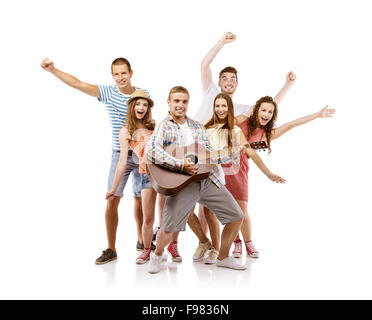 Gruppe der glückliche junge Menschen Spaß mit Gitarre, isoliert auf weißem Hintergrund. Beste Freunde Stockfoto