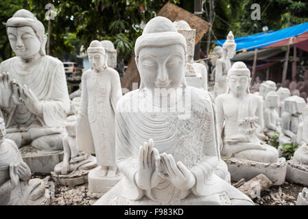 MANDALAY, Myanmar – lokale Handwerker machen die staubigen und rücksichtsvollen Arbeiten, die Statuen des Buddha aus Marmor schnitzen. Da der Buddhismus die dominierende Religion in Myanmar ist, besteht eine beträchtliche Nachfrage nach den Statuen, wobei Kunden aus einer Vielzahl von Posen, Größen und Stilen wählen können. Die Kunsthandwerker befinden sich in einer Straße im Chanmyathazi-Viertel Mandalay in der Nähe der Mahamuni-Pagode. Stockfoto