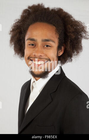 Schöner schwarzer Mann im Anzug Mantel mit einem zufrieden Lächeln Stockfoto