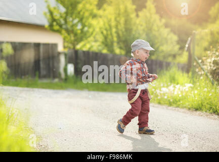 Kleiner Junge läuft auf der Straße Landschaft Stockfoto