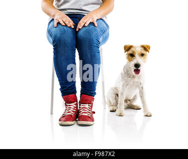 Niedliche Parson Russell Terrier Hund sitzt neben Frau isoliert auf weißem Hintergrund Stockfoto