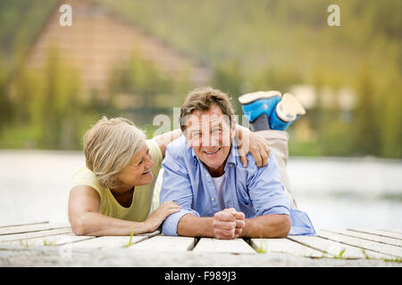 Älteres paar hinlegen und Spaß am pier Stockfoto