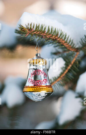 Weihnachtskugel auf einer Tanne mit Schnee im freien Stockfoto