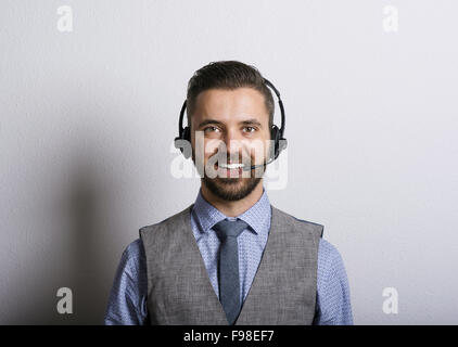 Call Center-Betreiber isoliert auf weiss. Junge hübsche Hipster Mann mit Kopfhörer. Stockfoto