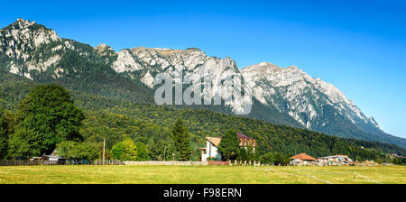 Karpaten, Rumänien. Sonnige Sommerlandschaft mit steilen Bucegi mit Caraiman Mount (2284 m) gesehen von Busteni, Prahova Stockfoto