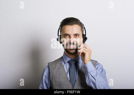 Call Center-Betreiber isoliert auf weiss. Junge hübsche Hipster Mann mit Kopfhörer. Stockfoto